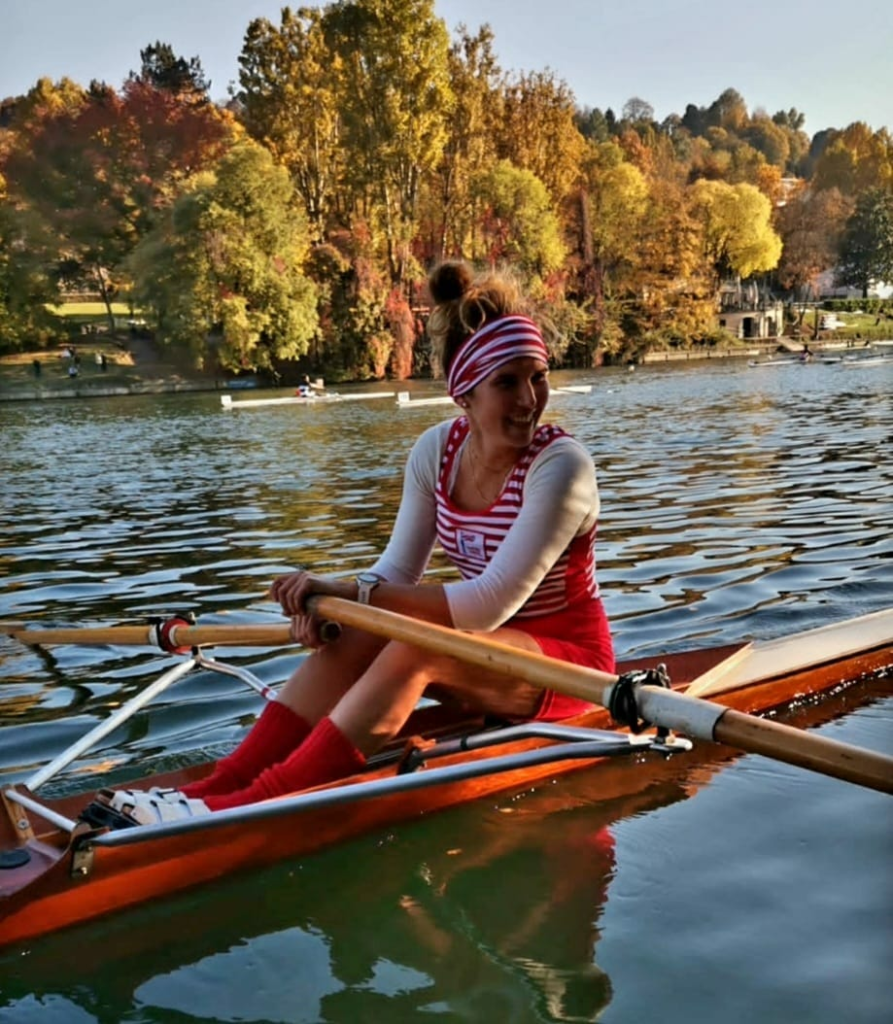 Female SilverVintage competitor dressed in period-approporiate rowing attire and classic wooden sculling boat